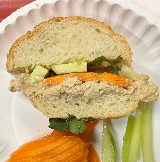 To show the Vietnamese Banh Mi Bite once sliced and assembled. The crumbled tofu is layered alongside pickled carrots, cucumber, and hummus, between a sliced baguette.